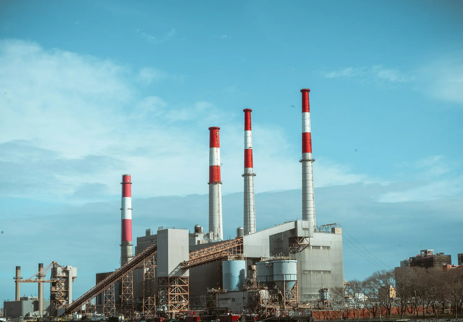 gray and red factory building under a calm blue sky